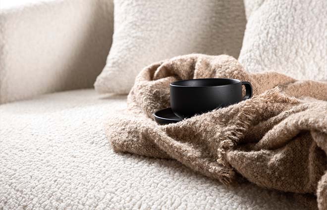 Cup on blanket on sofa